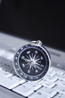 magnetic compass on a laptop, business travel concept