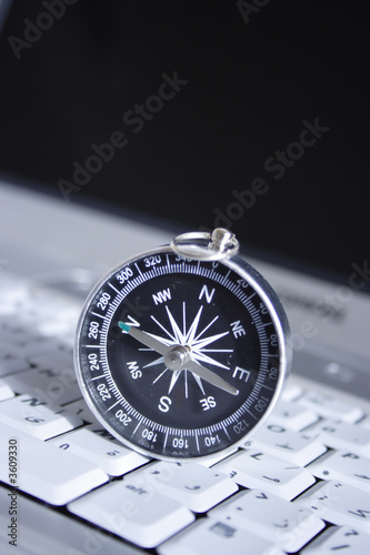 magnetic compass on a laptop, business travel concept magnetic compass on a laptop, business travel concept
