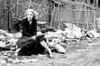 A beautiful young woman sits in the cold 