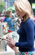 A young woman admires the bags through the window of a shop