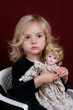 cute blond girl and doll  over red