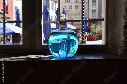 Vessel with a liquid in which the medieval city is reflected