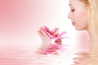 Beauty blonde spa girl with pink lily in water Beauty blonde spa girl with pink lily in water