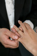 A groom putting a ring on his brides finger