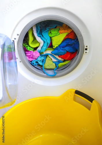 Photo: Close-up on a washing machine with clean colorful clothes Close-up on a washing machine with clean colorful clothes