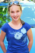 Portrait of a smiling young girl sitting on car hood