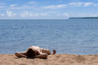 man laying on hot sand at beach