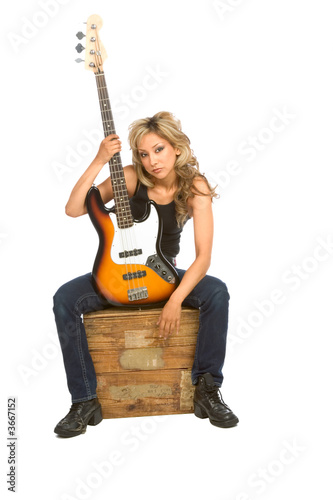 Photo: focus on guitara.Girl sitting on the box with bass guita focus on guitara.Girl sitting on the box with bass guita