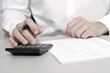 Foto: A businessman calculating expenses at tax time A businessman calculating expenses at tax time