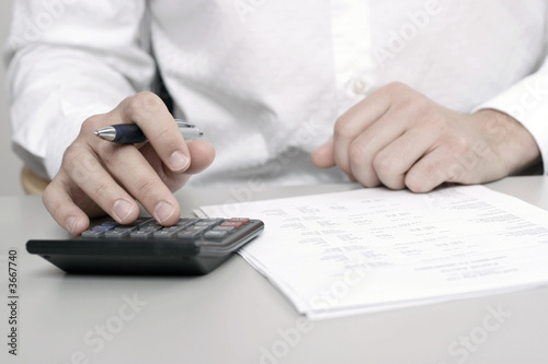 Photo : A businessman calculating expenses at tax time A businessman calculating expenses at tax time