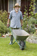 senior posing with a barrow in the garden