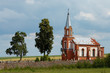 Small church and trees as countryside view against blue sky.