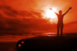 Fiery glory - woman with arms raised on sunset seascape