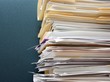 Photo: Pile of paperwork against a textured green cubicle wall Pile of paperwork against a textured green cubicle wall