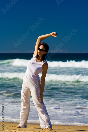 Foto: Young woman exercising on the tropical beach Young woman exercising on the tropical beach