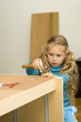 Girl helping to assemble a new furniture  