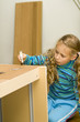 Girl helping to assemble a new furniture Girl helping to assemble a new furniture