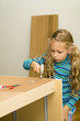 Girl helping to assemble a new furniture Girl helping to assemble a new furniture