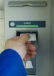 hand inserting blank card into cash machine