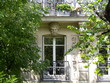 Fenêtre avec tête d'homme sculptée derrière arbres au soleil Fenêtre avec tête d'homme sculptée derrière arbres au soleil
