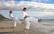 Young adult men practicing a Kata on the beach 