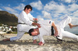 Men with black belt practicing fighting on the beach