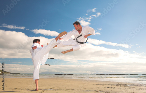 Photo: Young adult men practicing Karate on the beach Young adult men practicing Karate on the beach