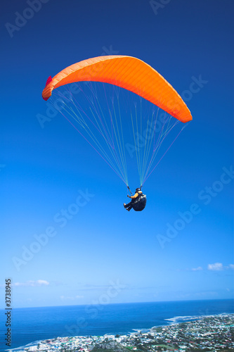 Photo: Paraglider launching from the ridge with an orange canopy Paraglider launching from the ridge with an orange canopy