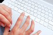 Main de jeune fille sur clavier blanc