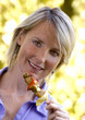 young woman eating chicken on a grill spit portrait