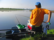Seated man fishing off a shoreline