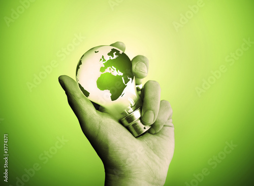 Photo: A man holding a light bulb with the world lighting up. A man holding a light bulb with the world lighting up.
