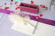 pink notebook and a feather pen on a wedding guest table