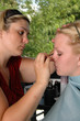 A makeup artist applies makeup to a model 