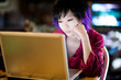 Beautiful geek sits at lap top computer