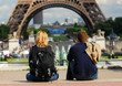 Young tourist couple sitting in front of Eiffel tower