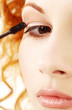 picture of lovely redhead applying black mascara