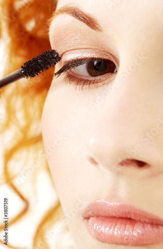 Foto: picture of lovely redhead applying black mascara picture of lovely redhead applying black mascara