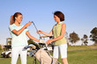 Two pretty women golfers selecting a golf club
