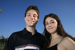 Photo: Smiling young couple embracing outdoors on a playing field Smiling young couple embracing outdoors on a playing field