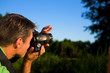 close up of man taking pictures outside on a field