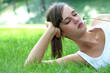 Young woman lying on lawn holding flower