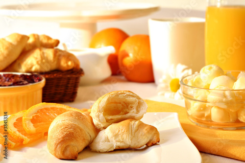 Foto: Fresh croissants with butter and jam, orange juice and coffee. Fresh croissants with butter and jam, orange juice and coffee.