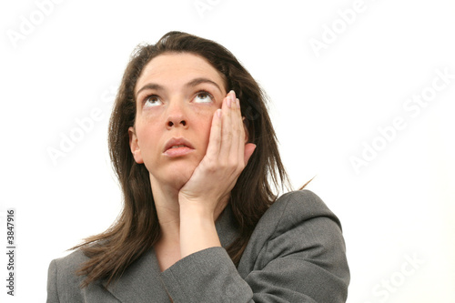 Photo: Worried business woman in a suit isolated over white background Worried business woman in a suit isolated over white background