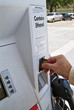A man using the credit card scanner at a gas station