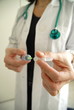 Docator holding with two hands a medical syringe