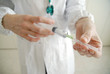 Docator holding with two hands a medical syringe