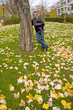 Middleaged man in a sweater and jeans leaned against a tree