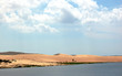 a beautiful landscape of sand dunes, lakes and clouds