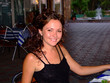 The young beautiful smiling girl sits at restaurant